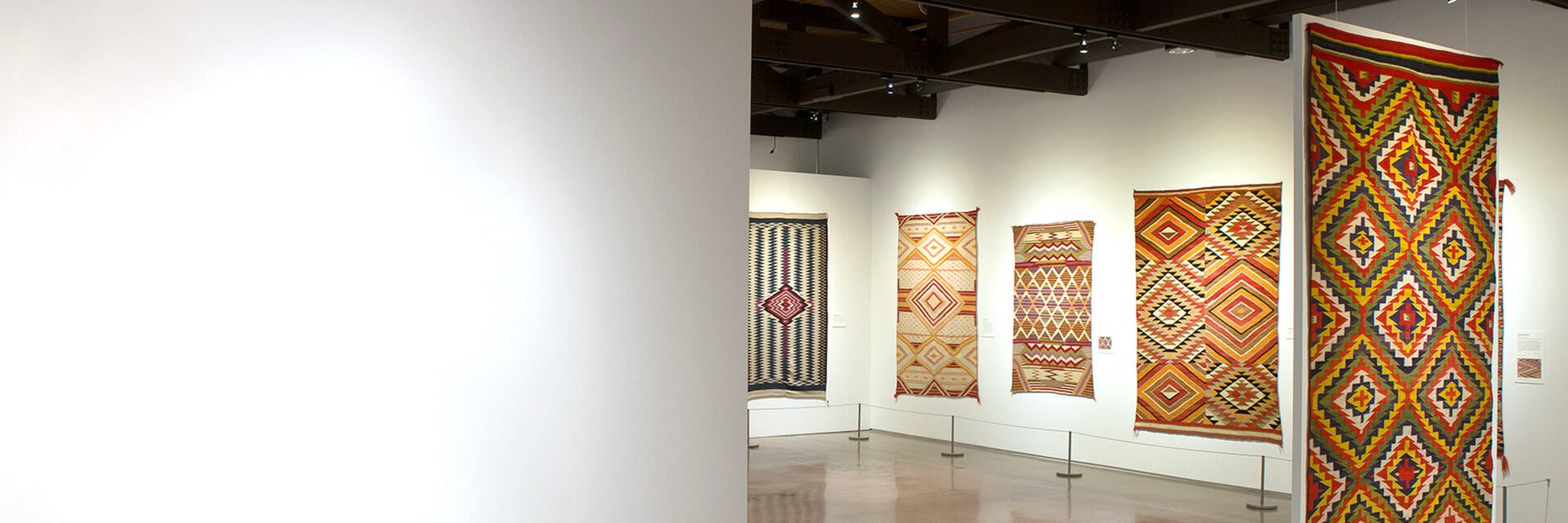 A collection of colorful rugs in a museum.