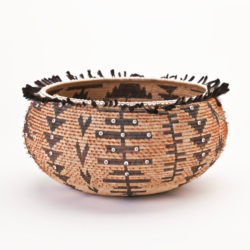 A basket with black and brown designs on it.