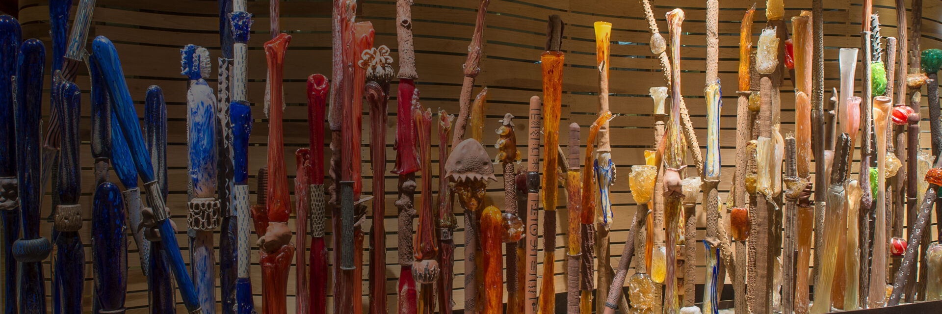 A display of many different colored sticks on a wall, known as the Art Fence.