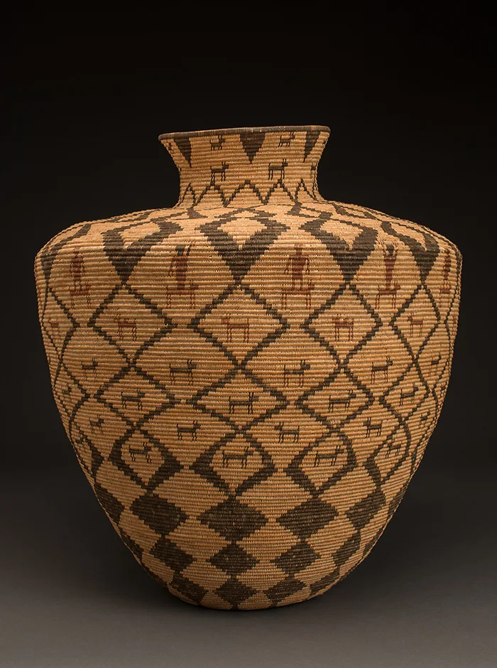 A woven vase with black and brown designs.