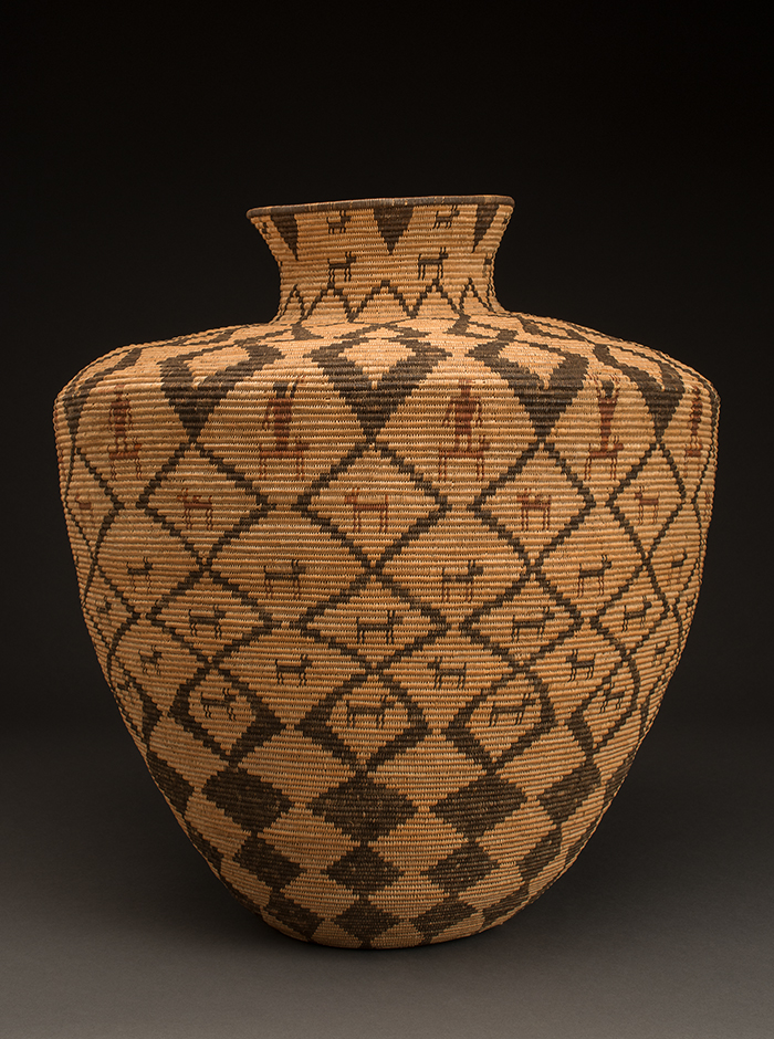 A woven vase with black and brown designs.