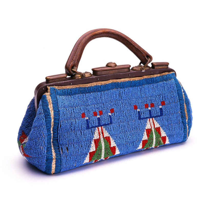 A blue beaded purse with a wooden handle.