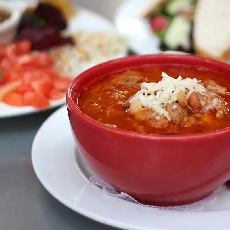 A bowl of soup and a salad on a table.
