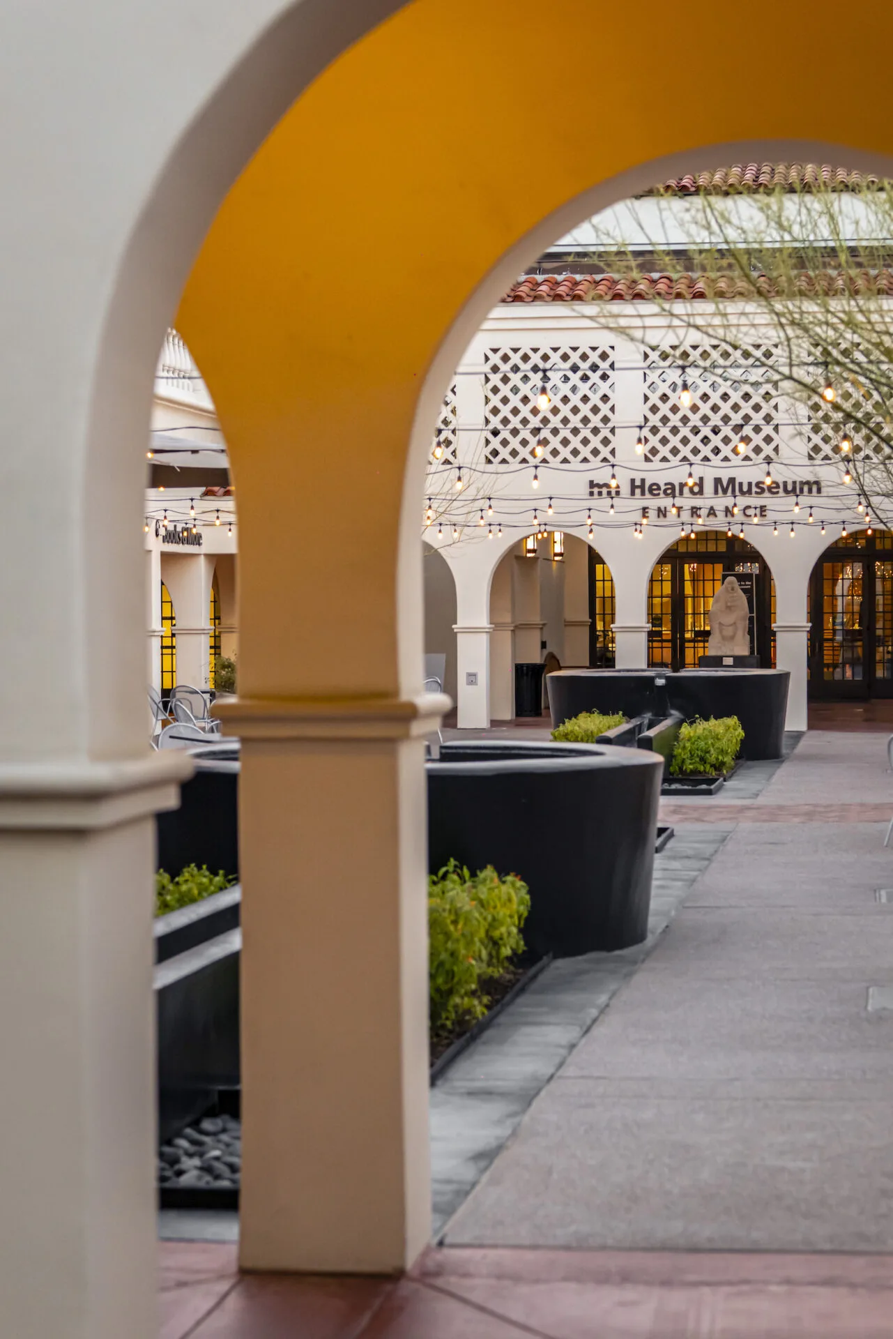 An archway leading to a courtyard with a fountain.