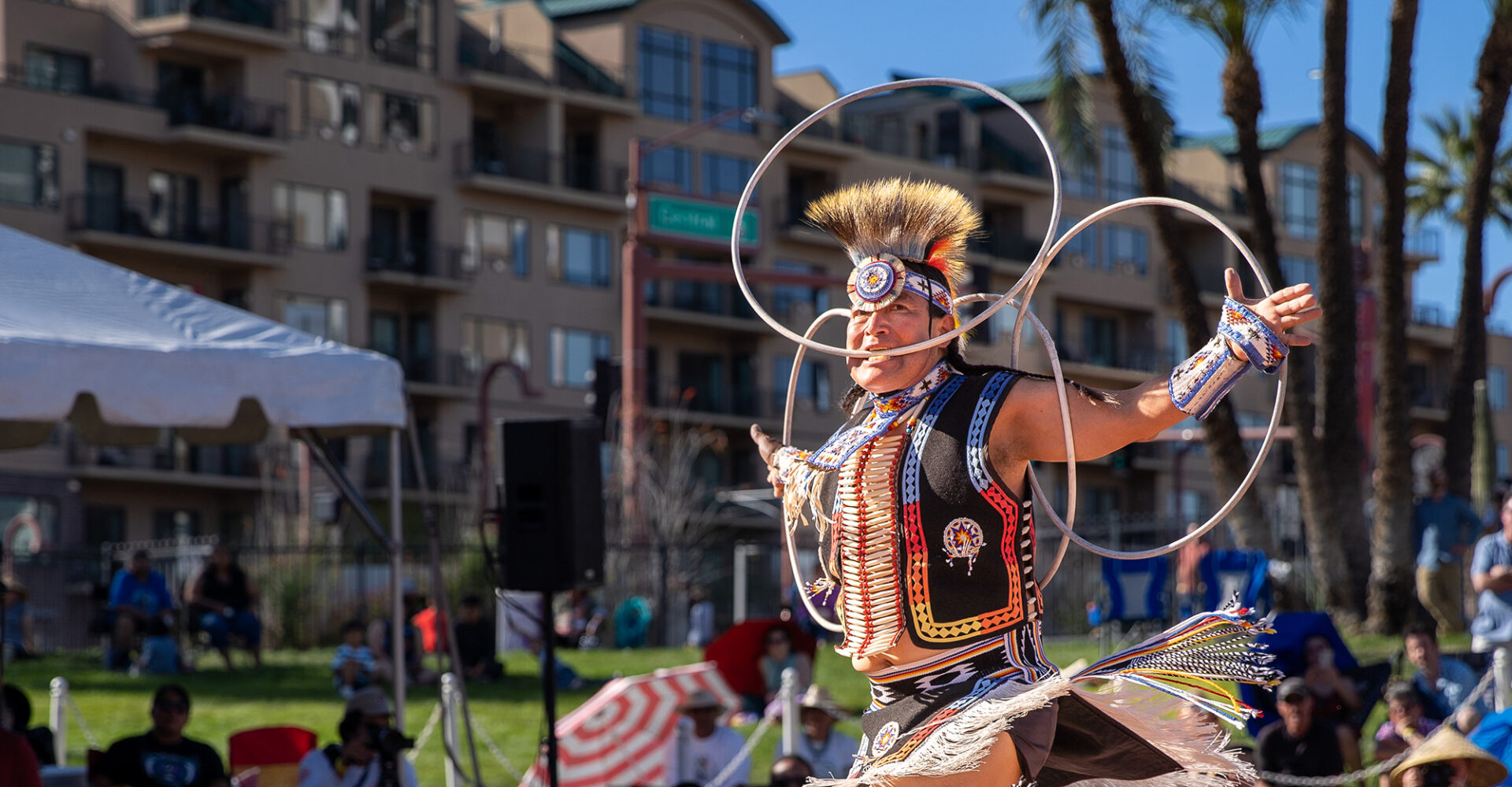 A Native American dancer performs a hoop dance.