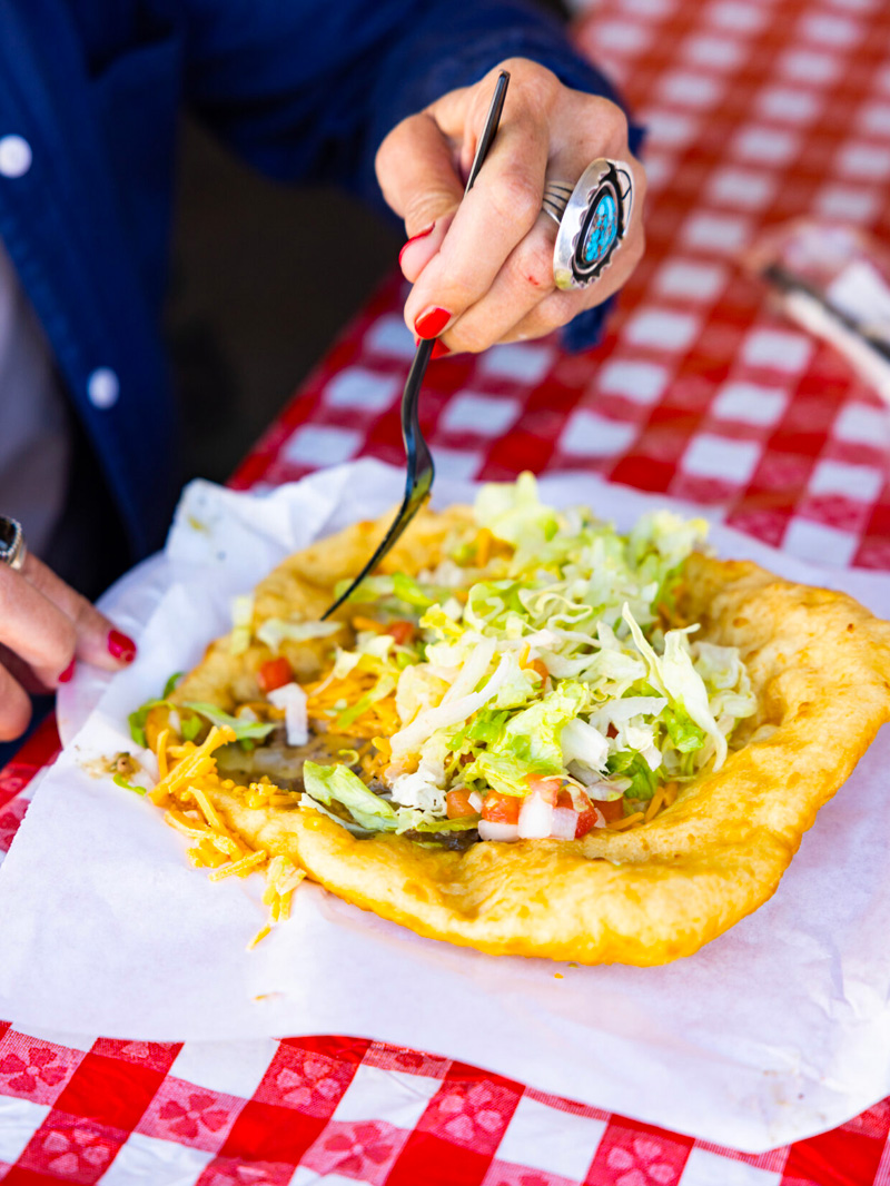 A person eating a taco with a fork.