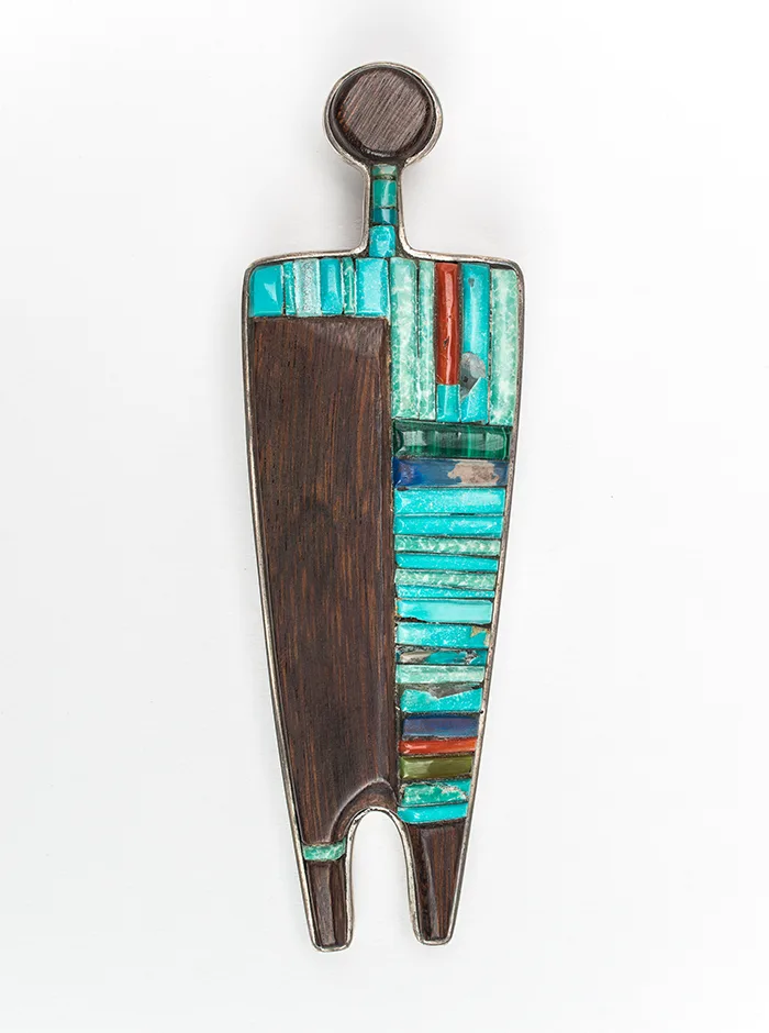 A wooden jewelry pendant with a blue and turquoise design.