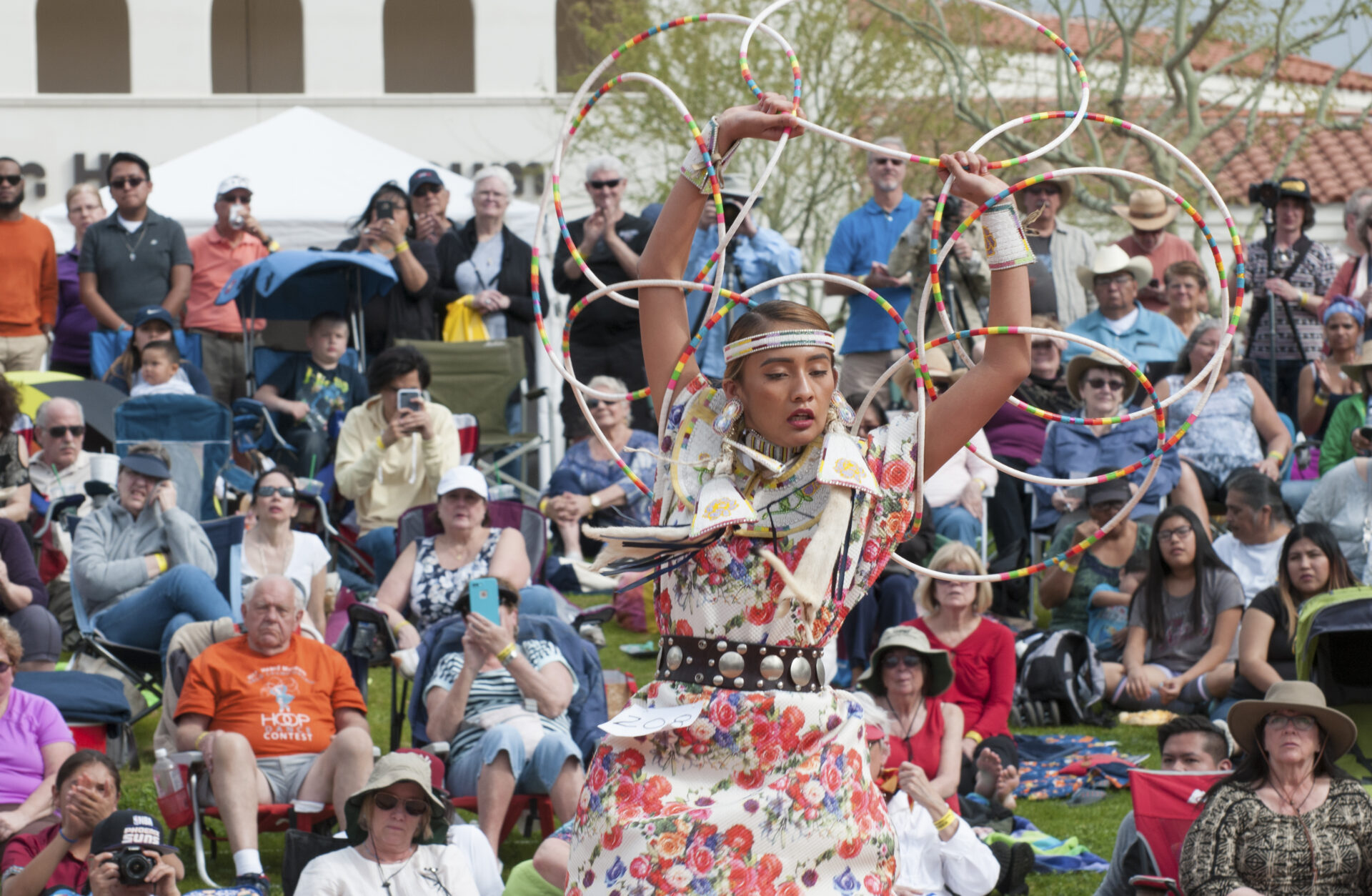 A Native American female dancer performs a hoop dance.
