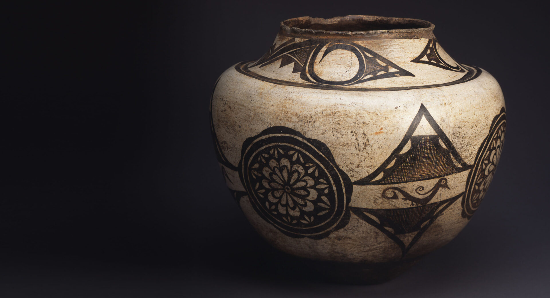 A white jar with brown designs on it.