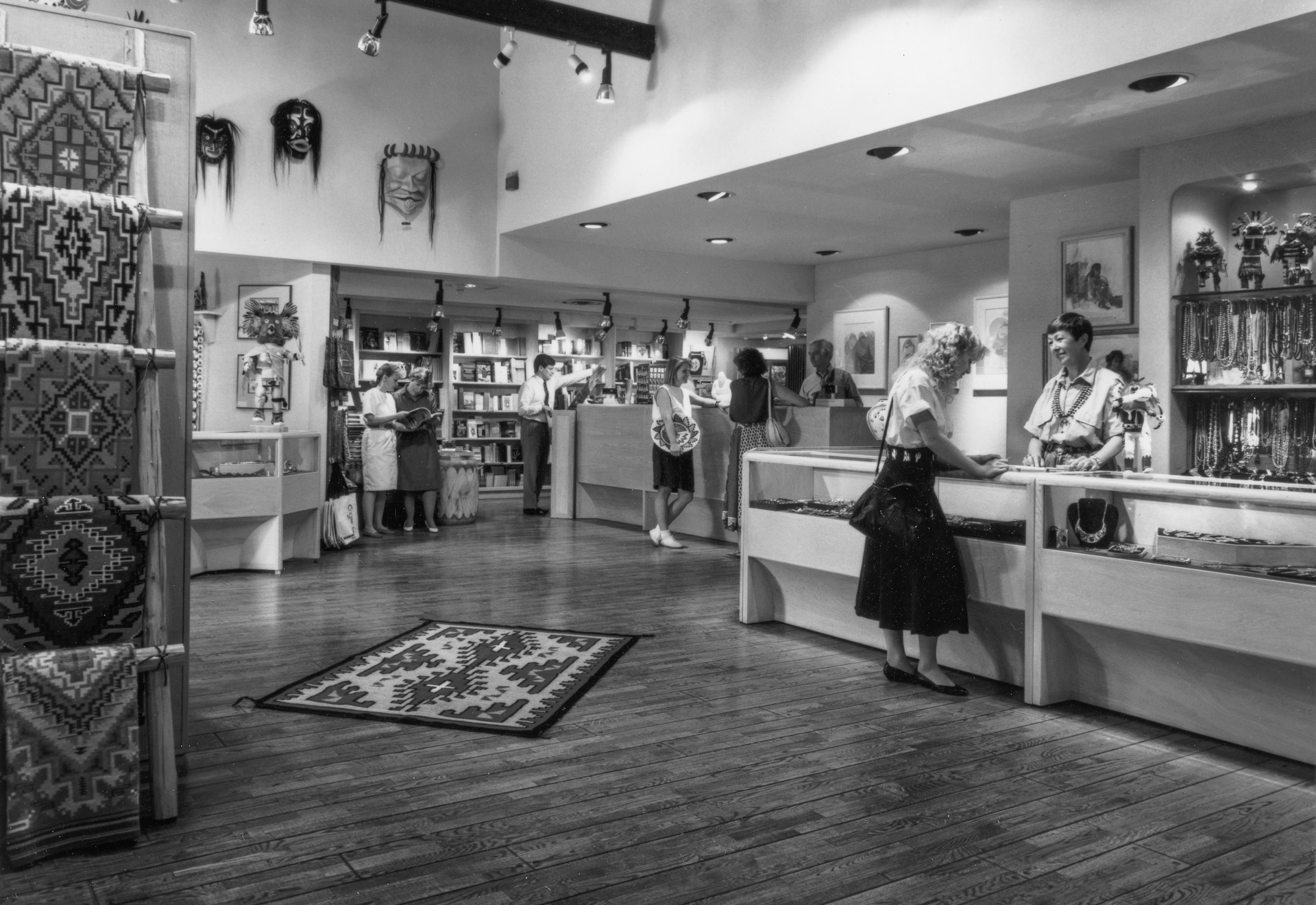 A black and white photo of a store with a lot of merchandise.