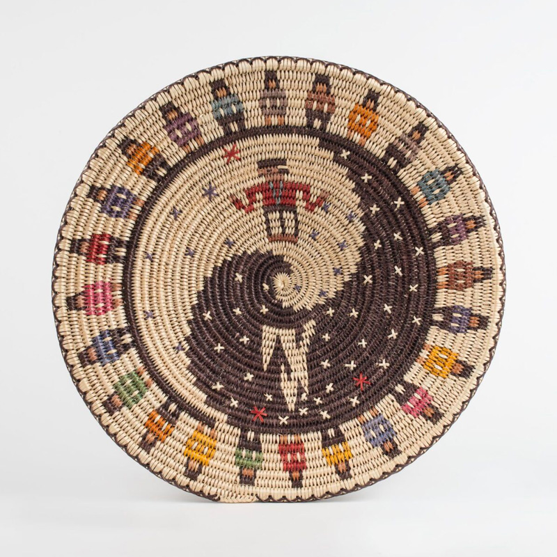 A woven basket with a colorful design on it.