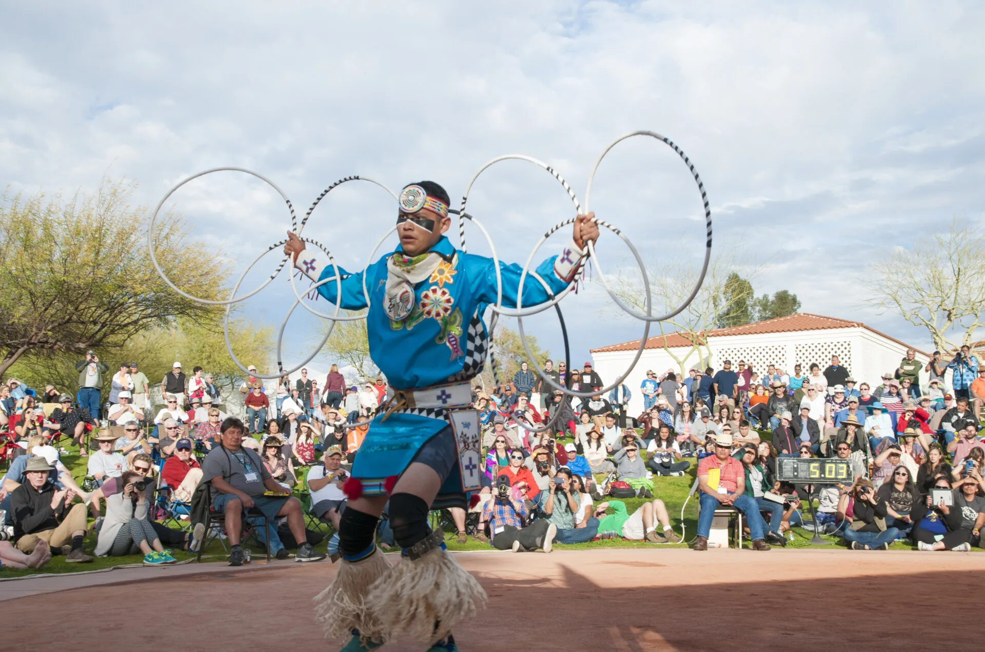 A Native American dancer performs a hoop dance.