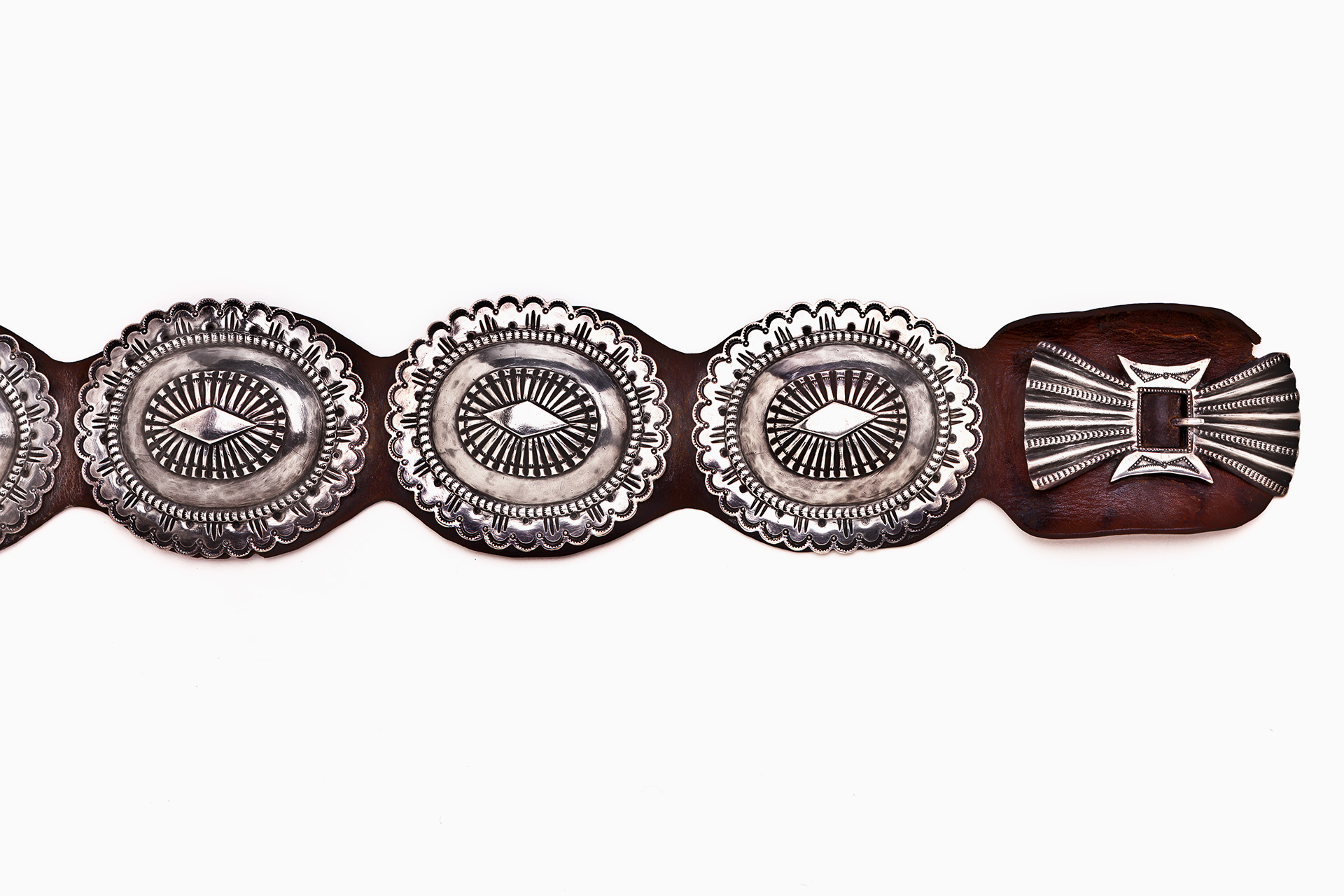 A silver and brown belt with a design on it.