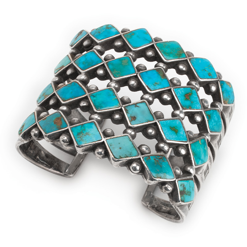 A silver cuff bracelet with turquoise stones.