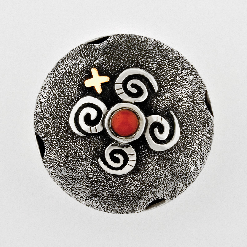 A silver and coral seed pot with a cross on it.