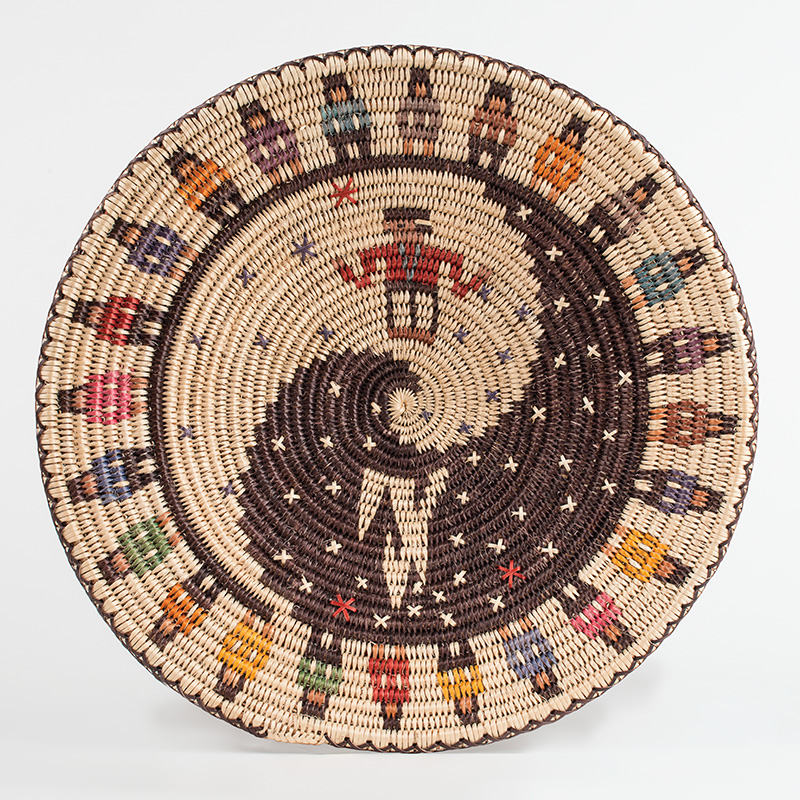A woven basket with a colorful design on it.