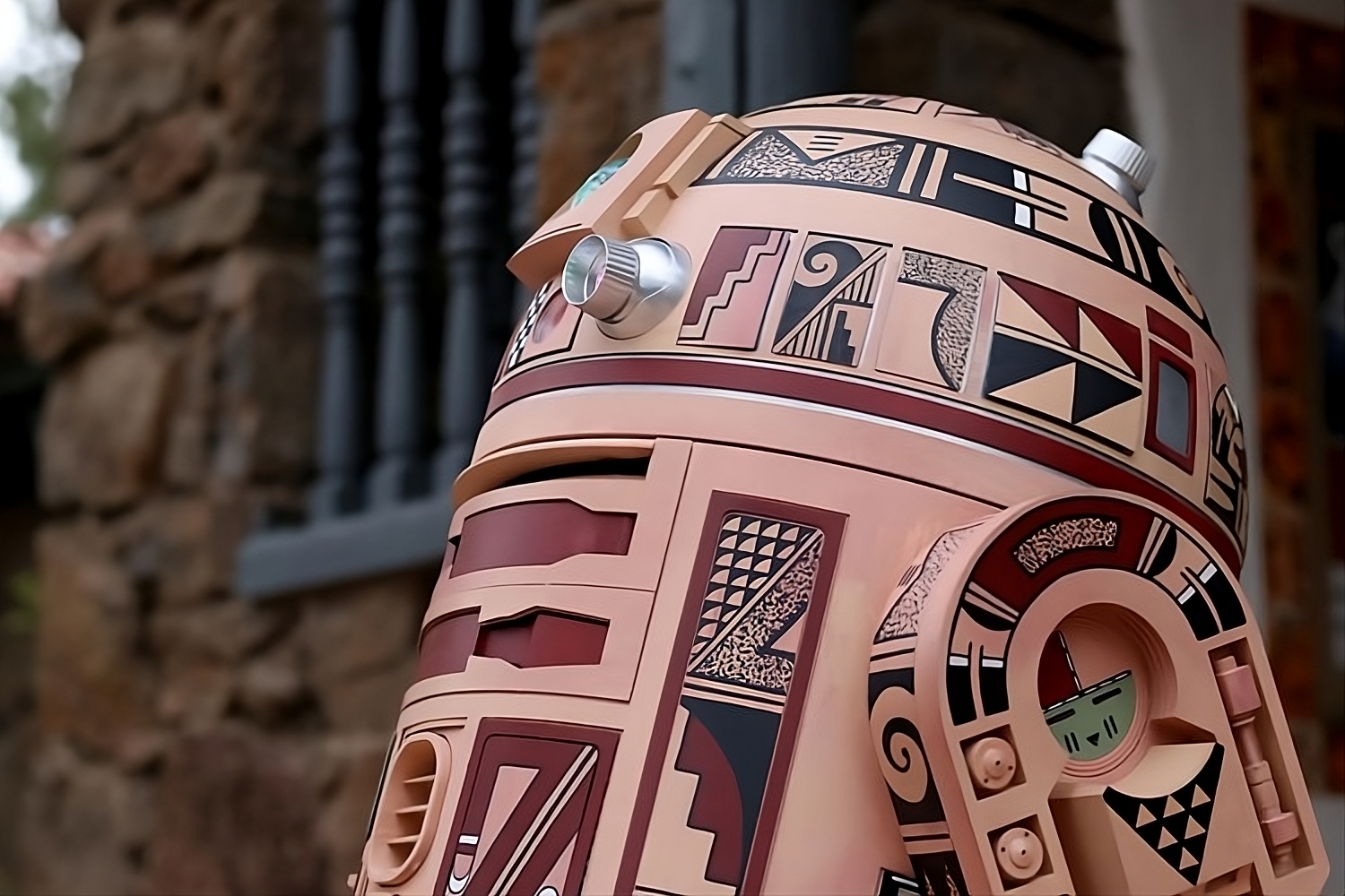 An R2D2 sculpture designed by a Hopi artist in front of a building.