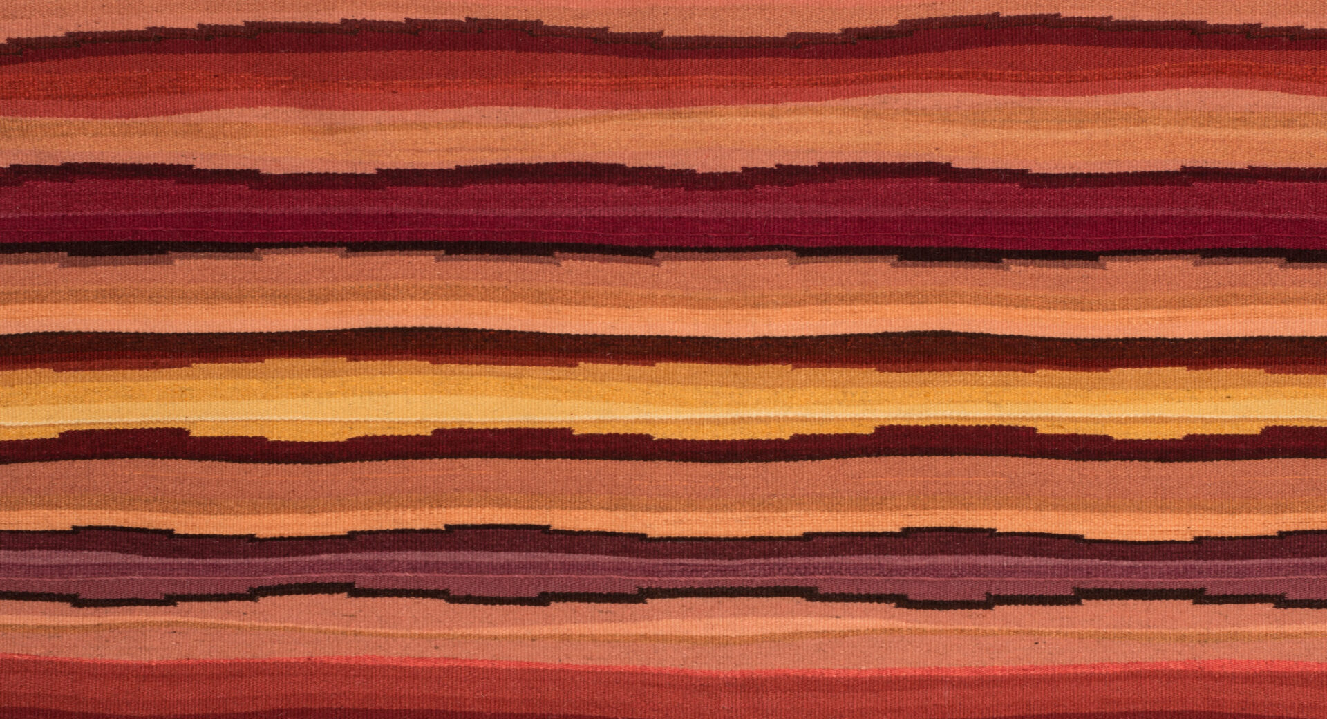 A textile with red, orange, and brown stripes.