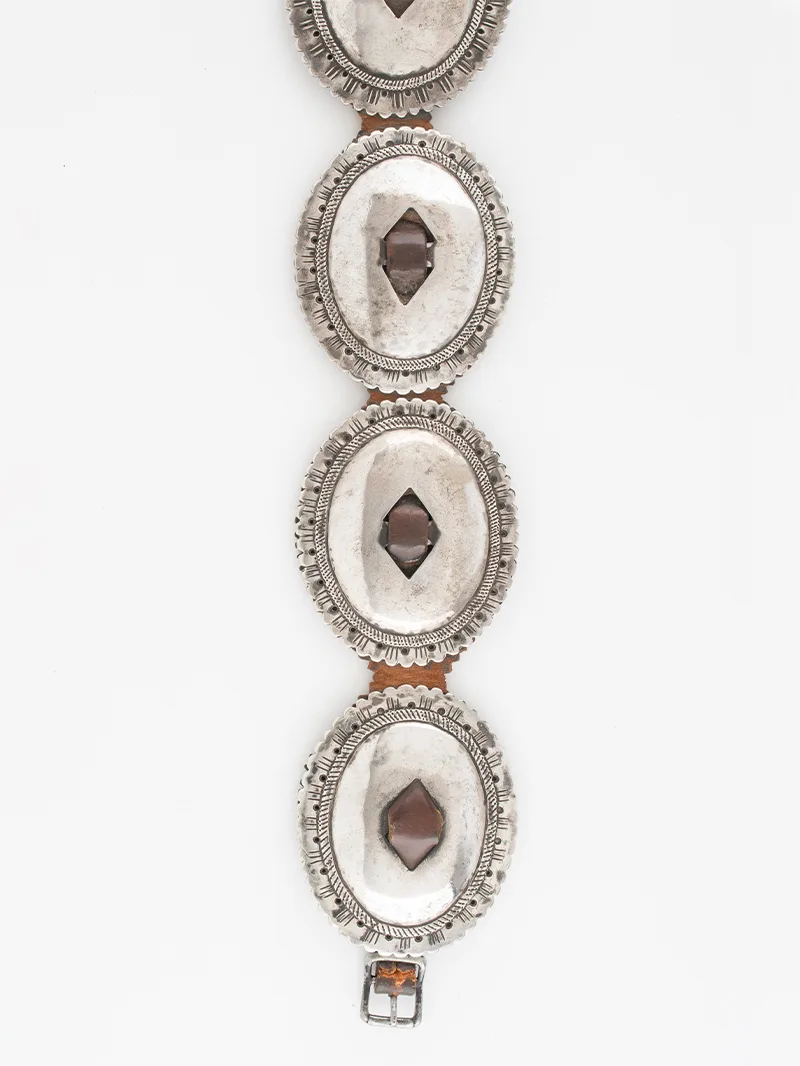A silver belt with brown stones on it.