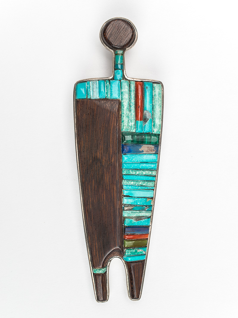 A wooden and turquoise pendant shaped like a figure.