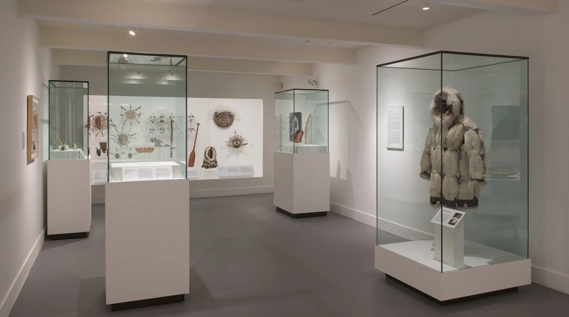 A museum with glass display cases and a winter coat garment.