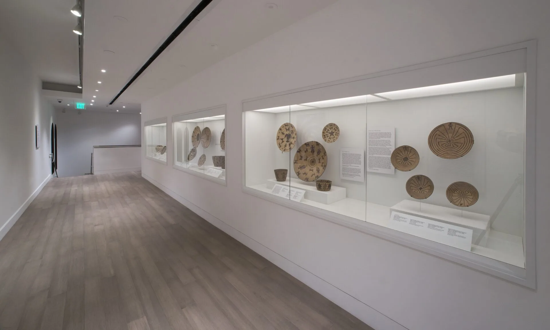 A hallway with a display of baskets in a gallery.