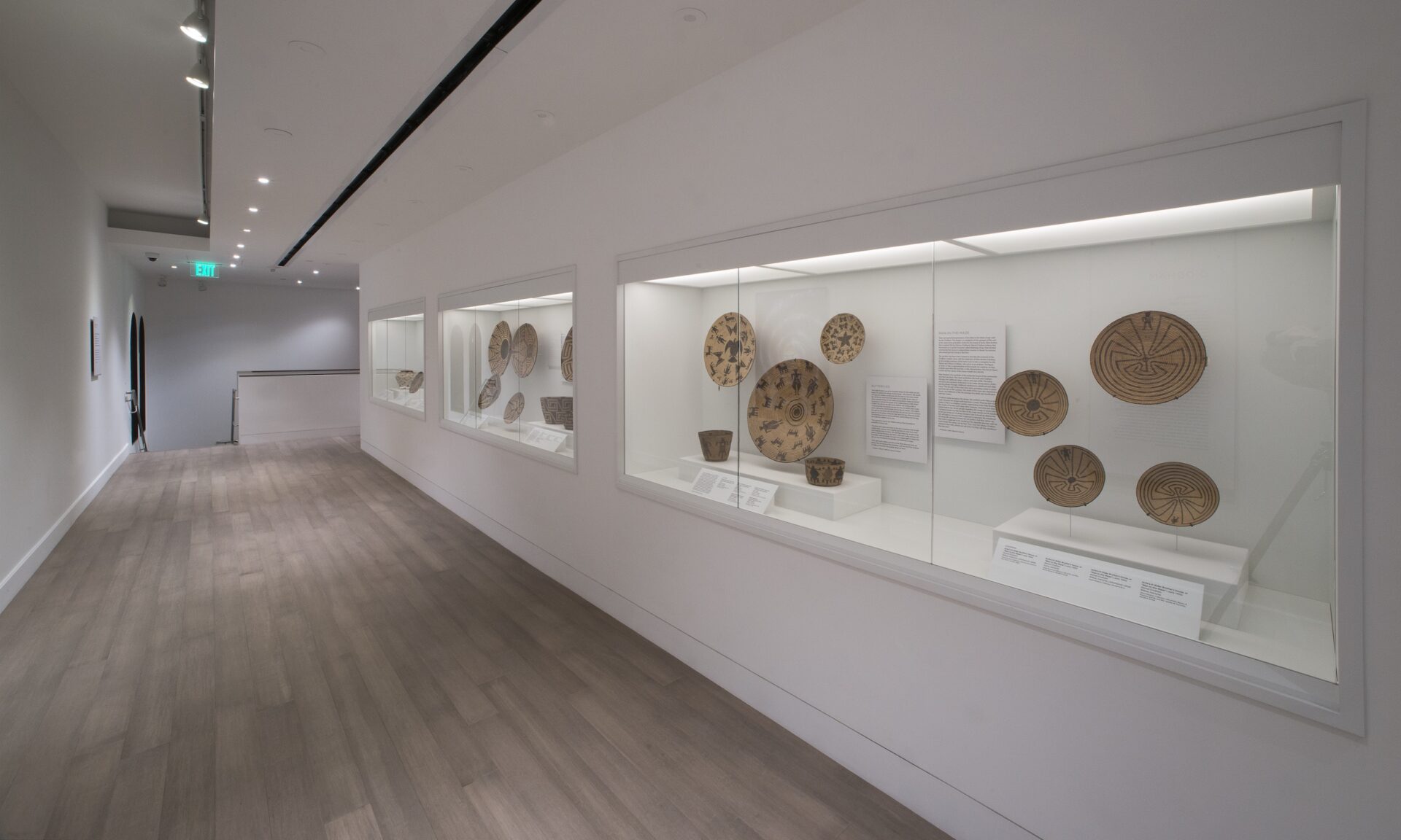 A hallway with a display of baskets in a gallery.