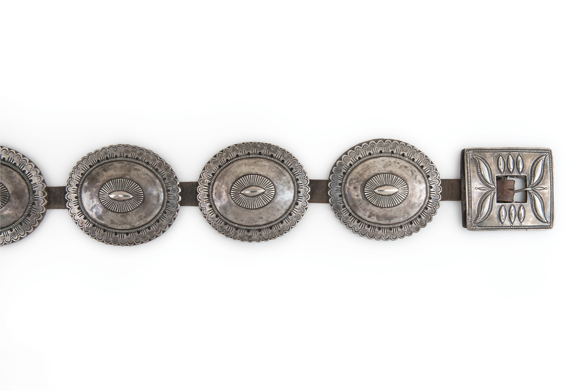 A silver belt with a large number of medallions on it.