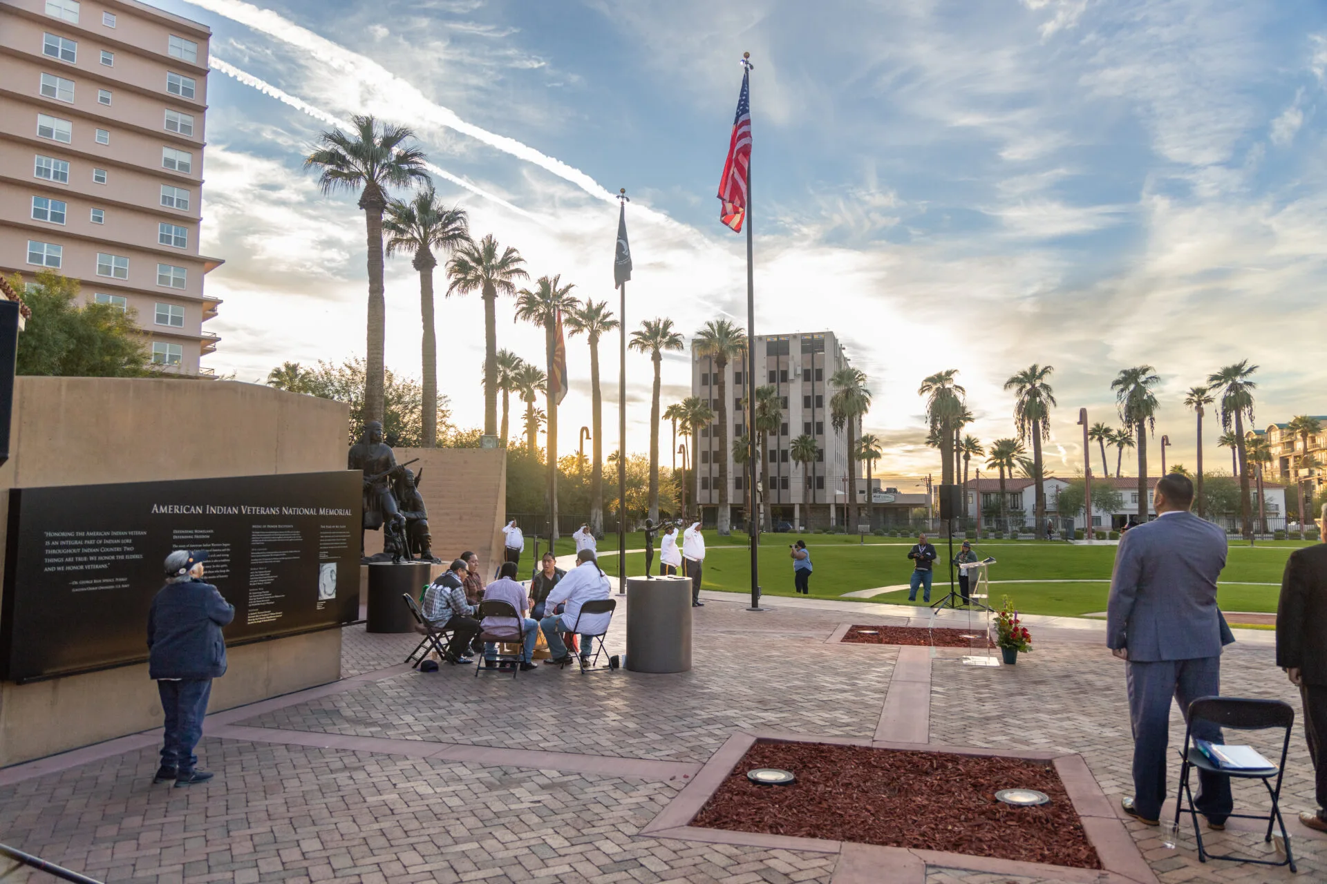 A group of people standing in front of a veterans memorial.