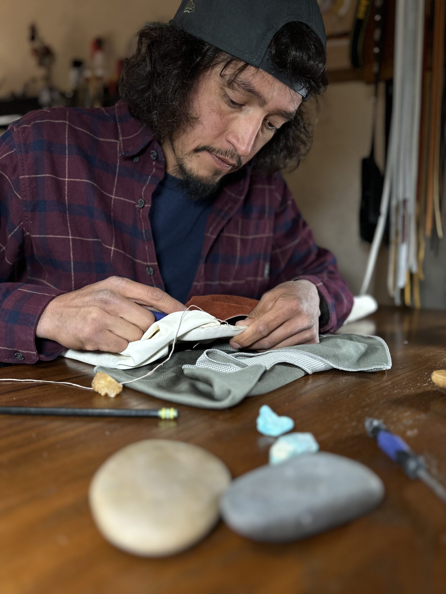 A man is working on a piece of moccasin.