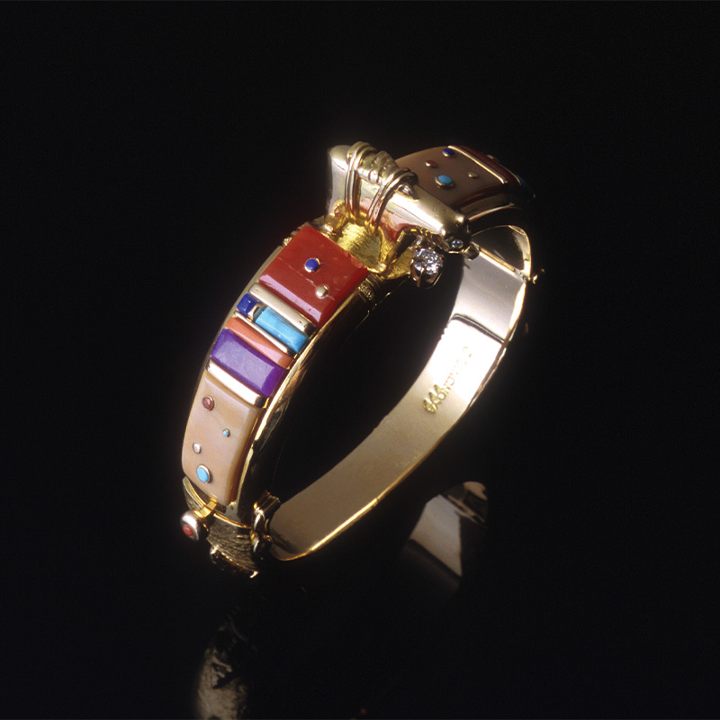 A gold plated bracelet with multicolored stones.
