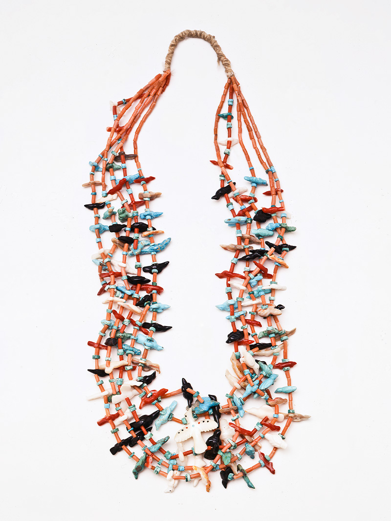 A necklace with turquoise, orange and black beads.
