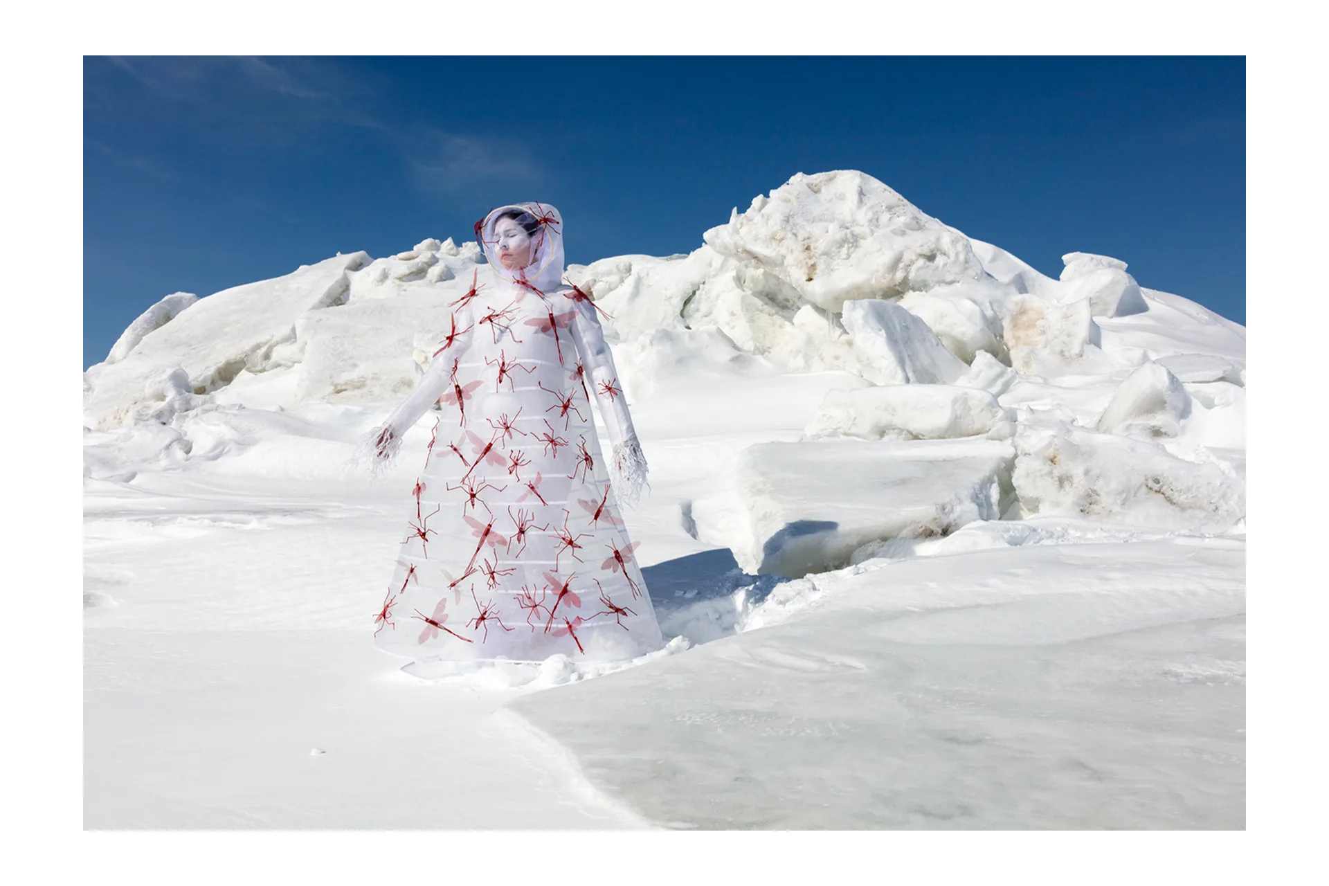 A woman in a white and red dress standing in the snow.