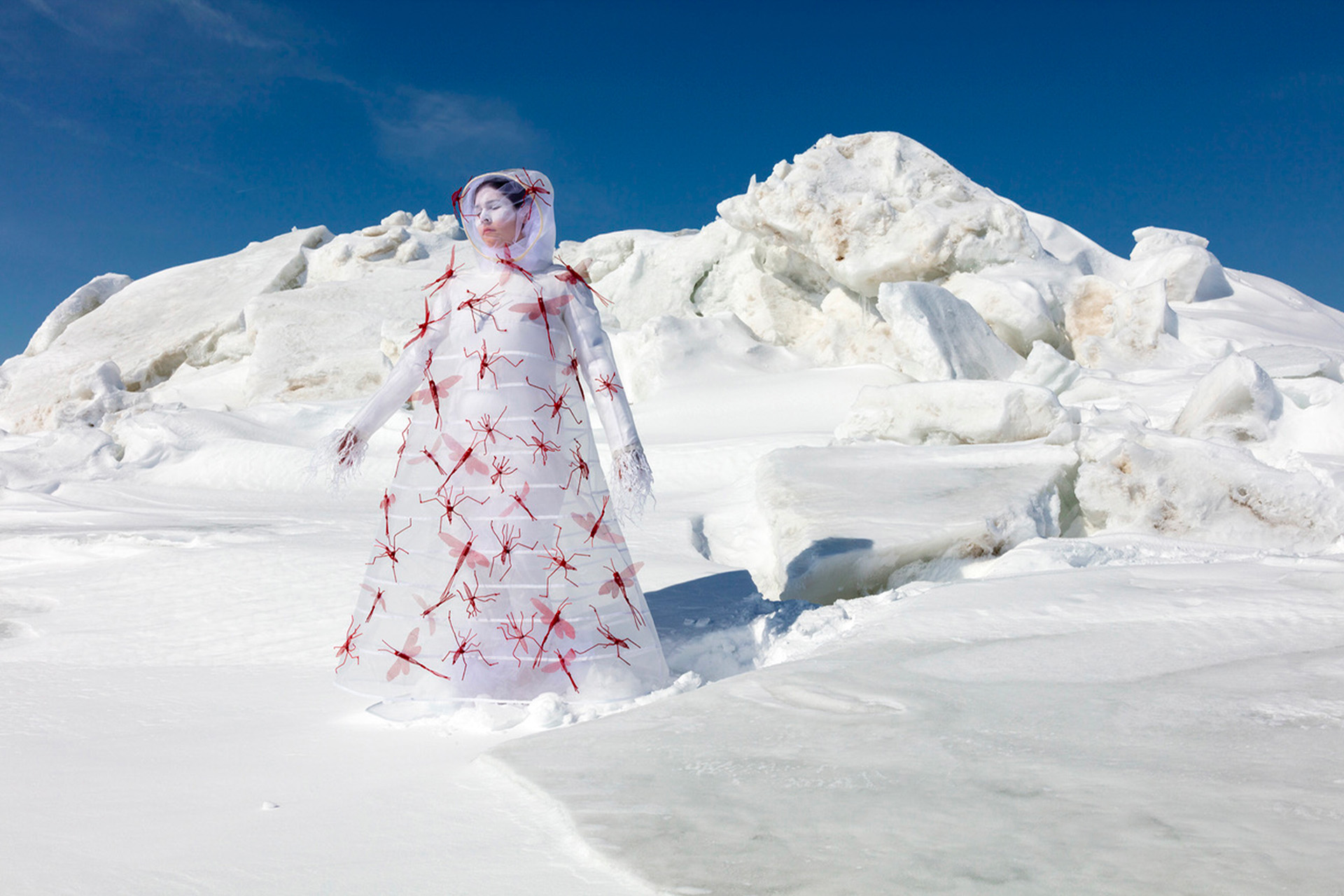 A woman in a white and red dress standing in the snow.