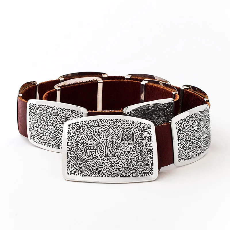 A brown belt with a large number of ornately designed silver medallions on it.