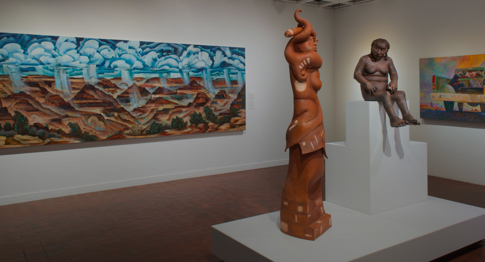A sculpture sits on a pedestal in an art gallery with paintings on the walls.