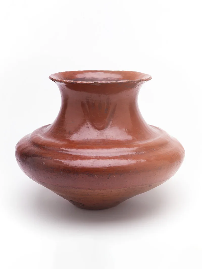 A small brown jar with a flat lip on a white background.