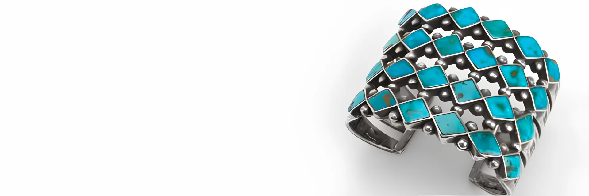 A silver cuff with turquoise stones on it.