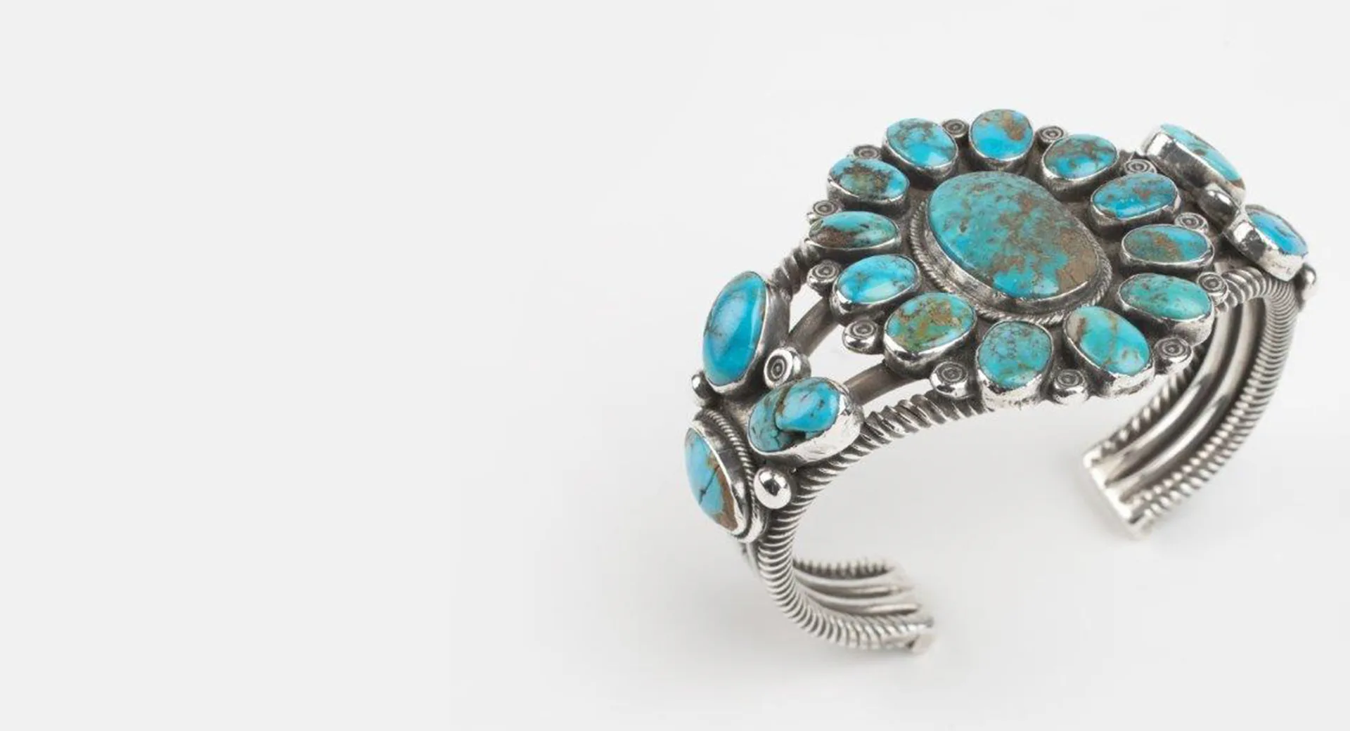 A silver cuff bracelet with turquoise stones.