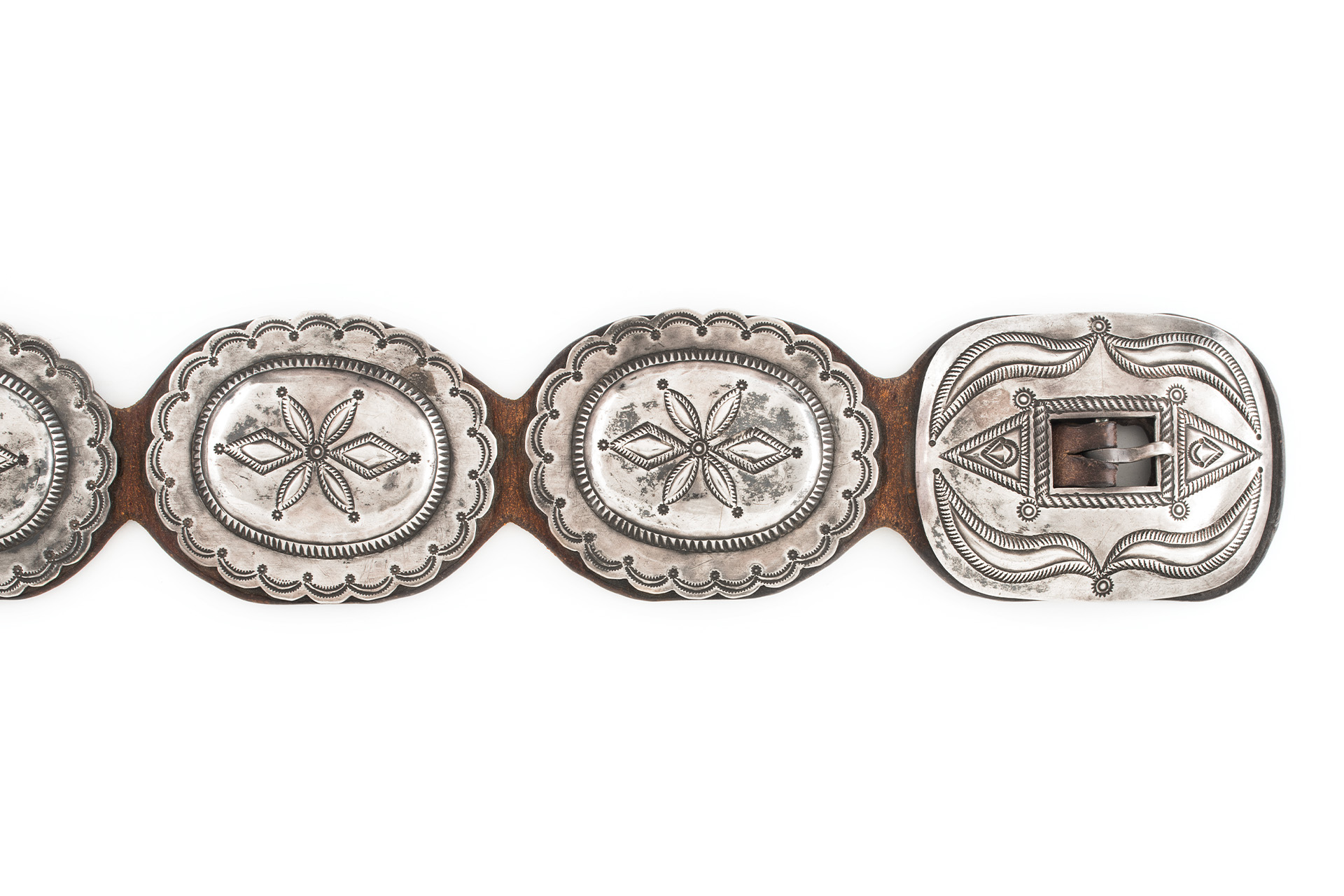 A silver belt with flower designs on it.