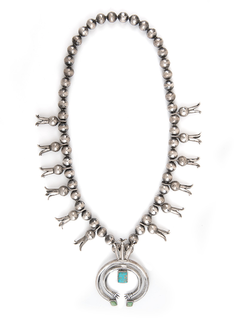 A silver necklace with a turquoise stone.