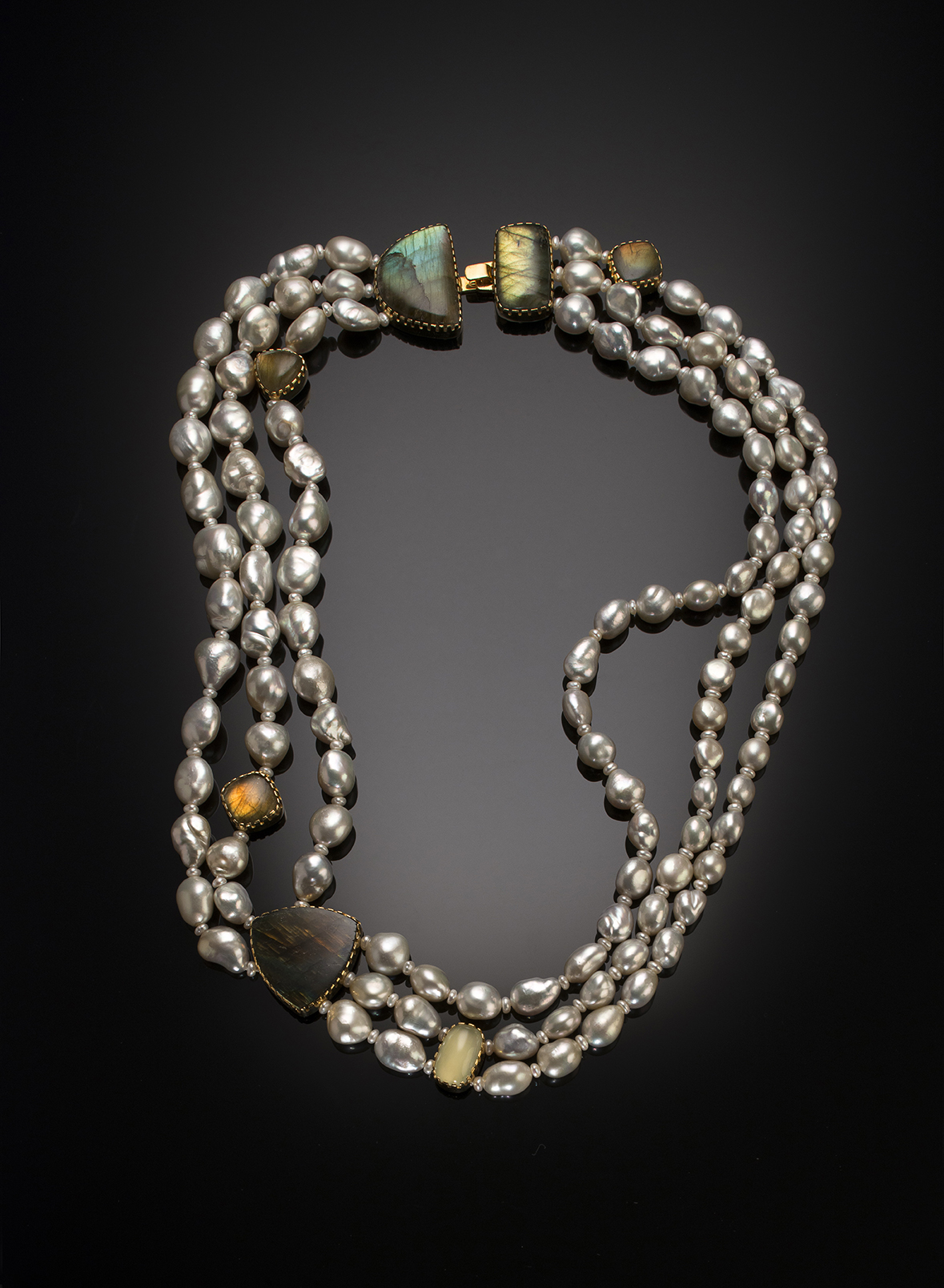 A silver and gold necklace with stones and beads.
