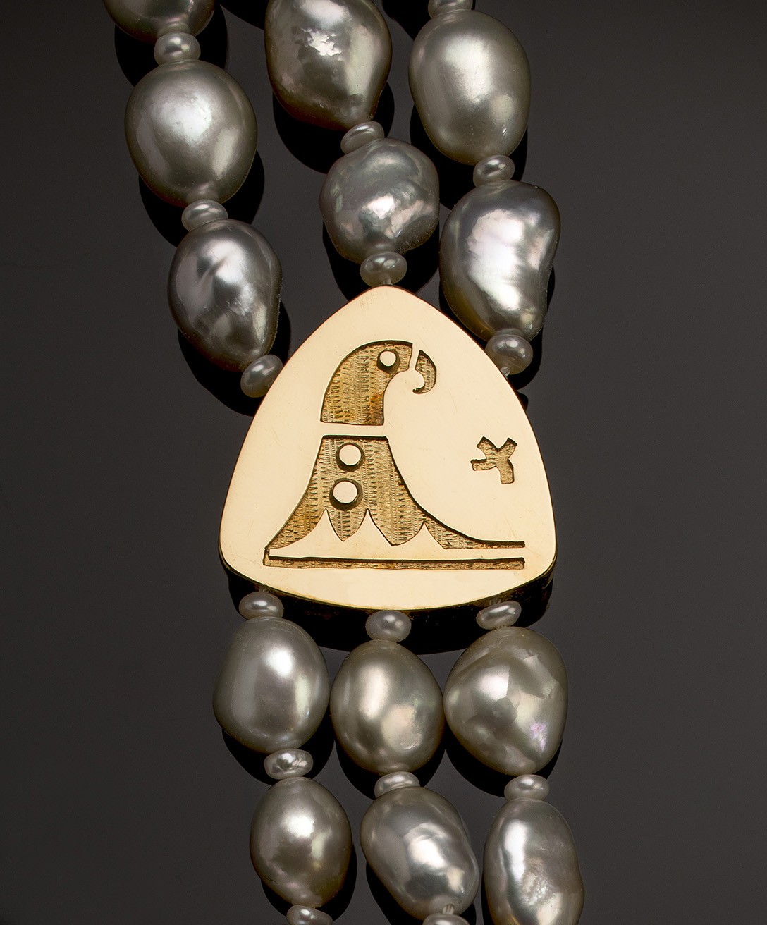A necklace with a pendant and pearls.