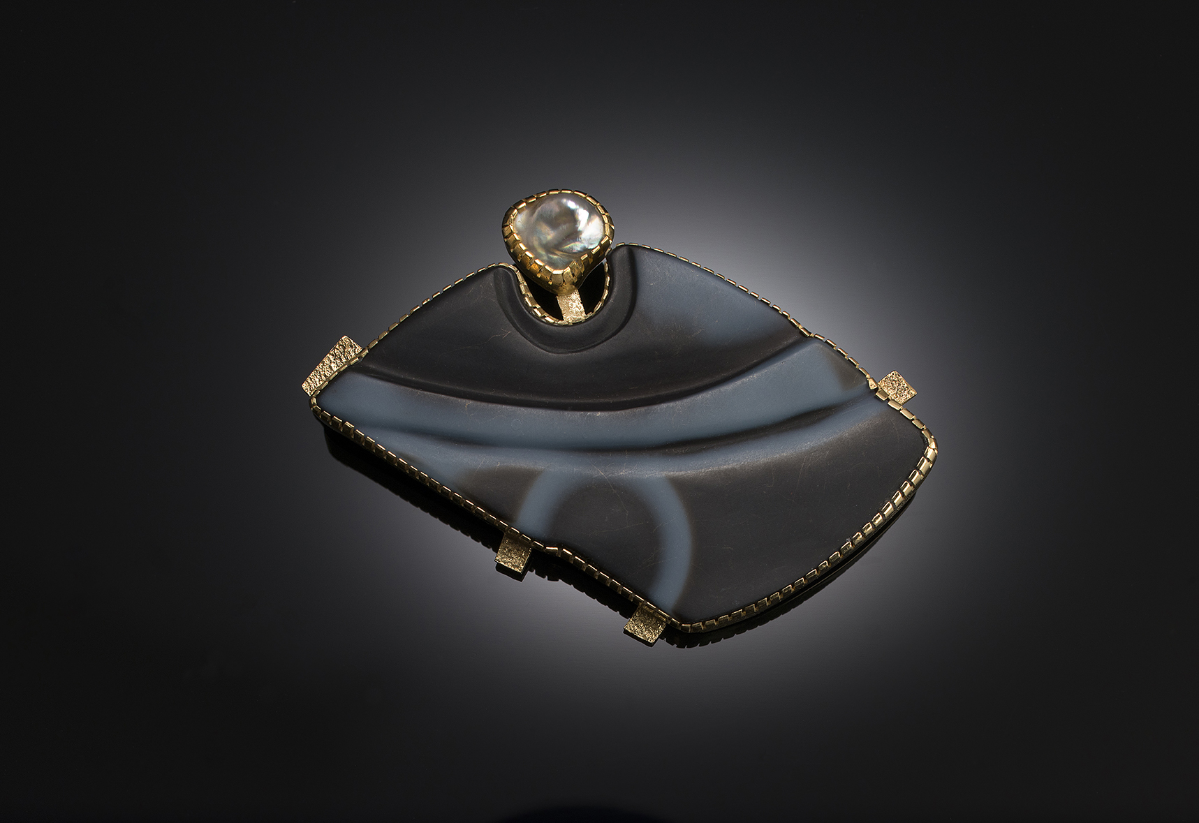 An agate and diamond pendant on a black background.