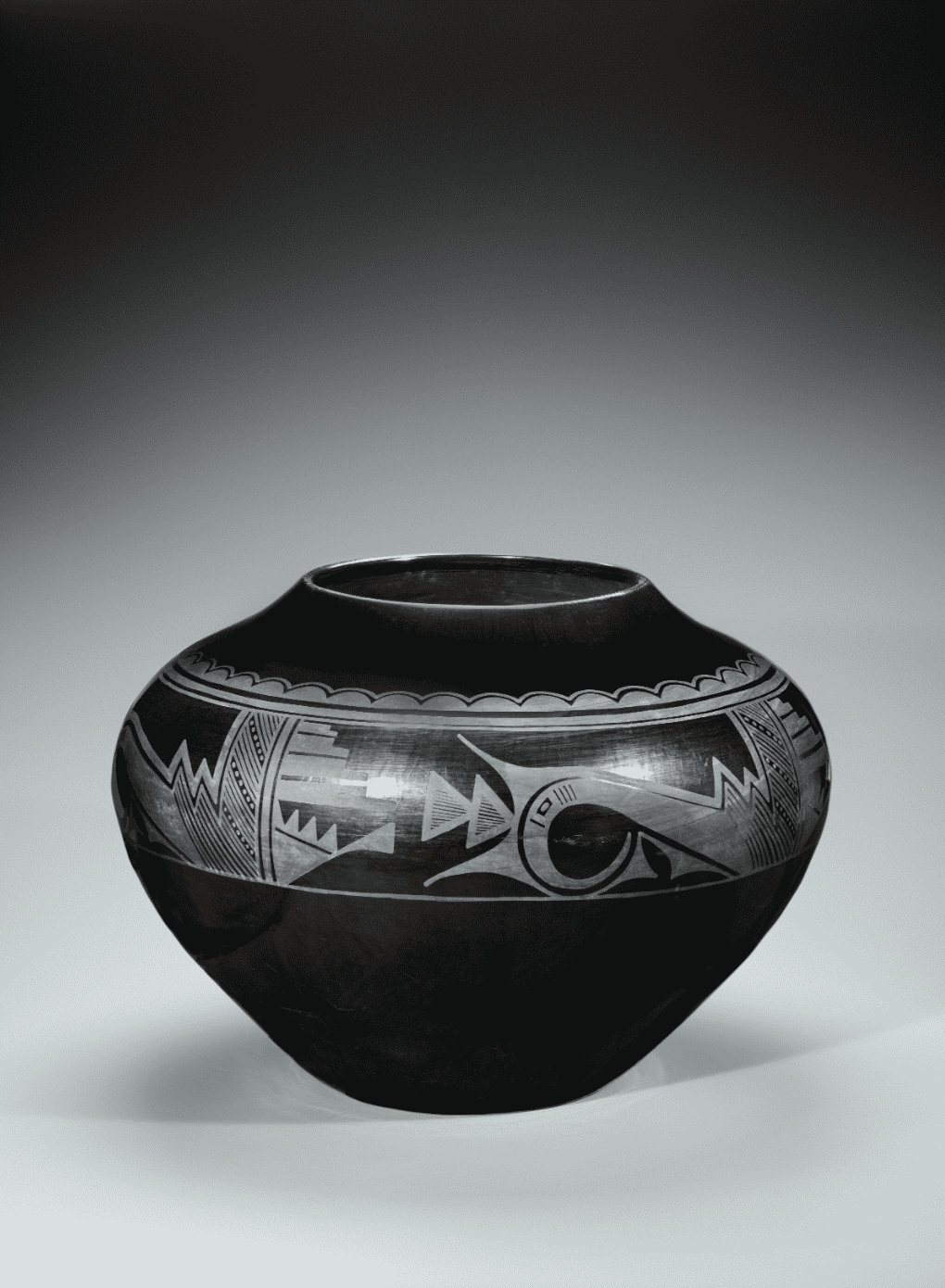 A black and white vase with designs on it.