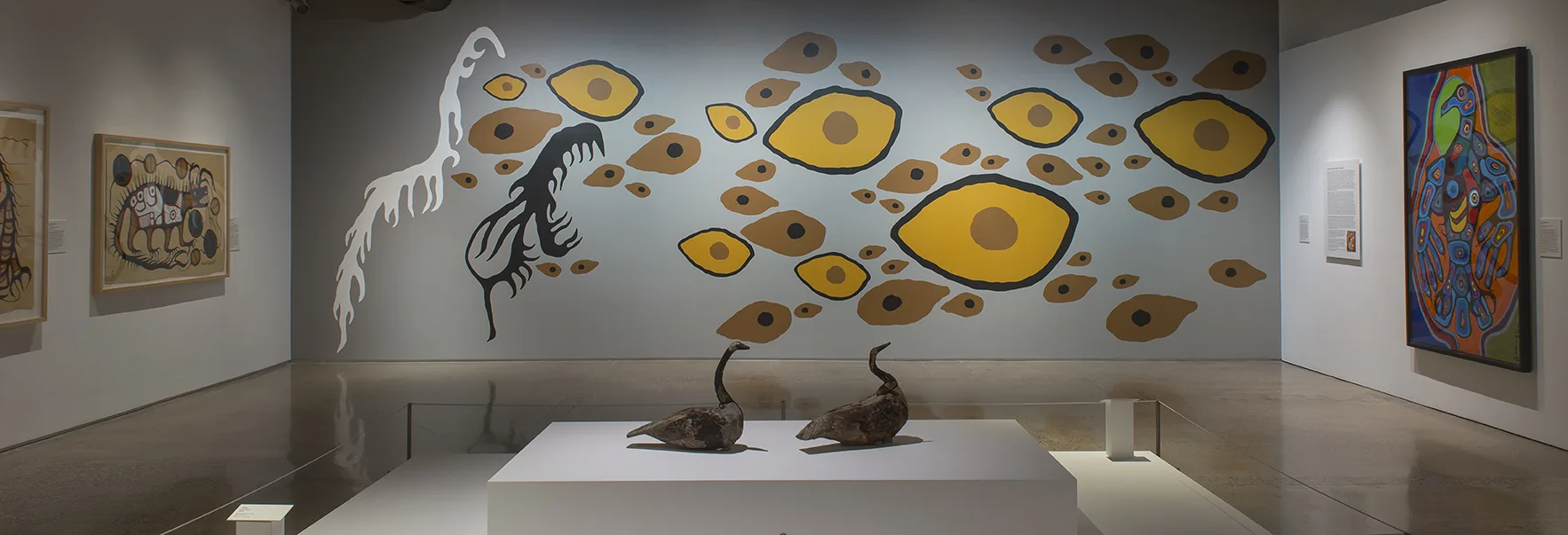 A room with paintings and sculptures on display.