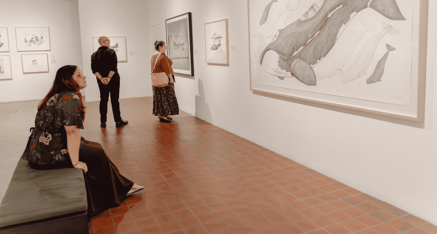 A group of people looking at art in an art gallery.