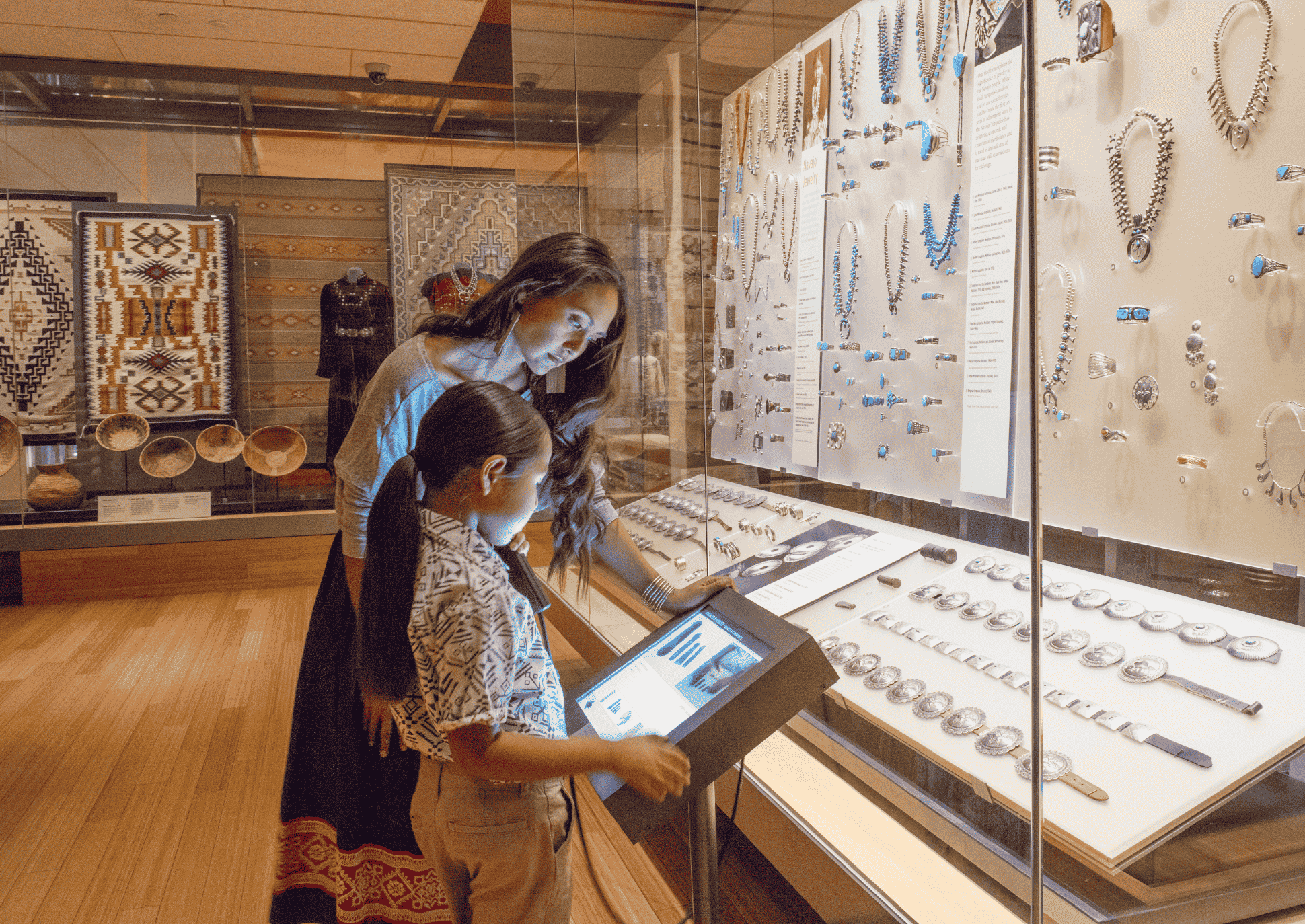 A woman and a child looking at a display of jewelry.