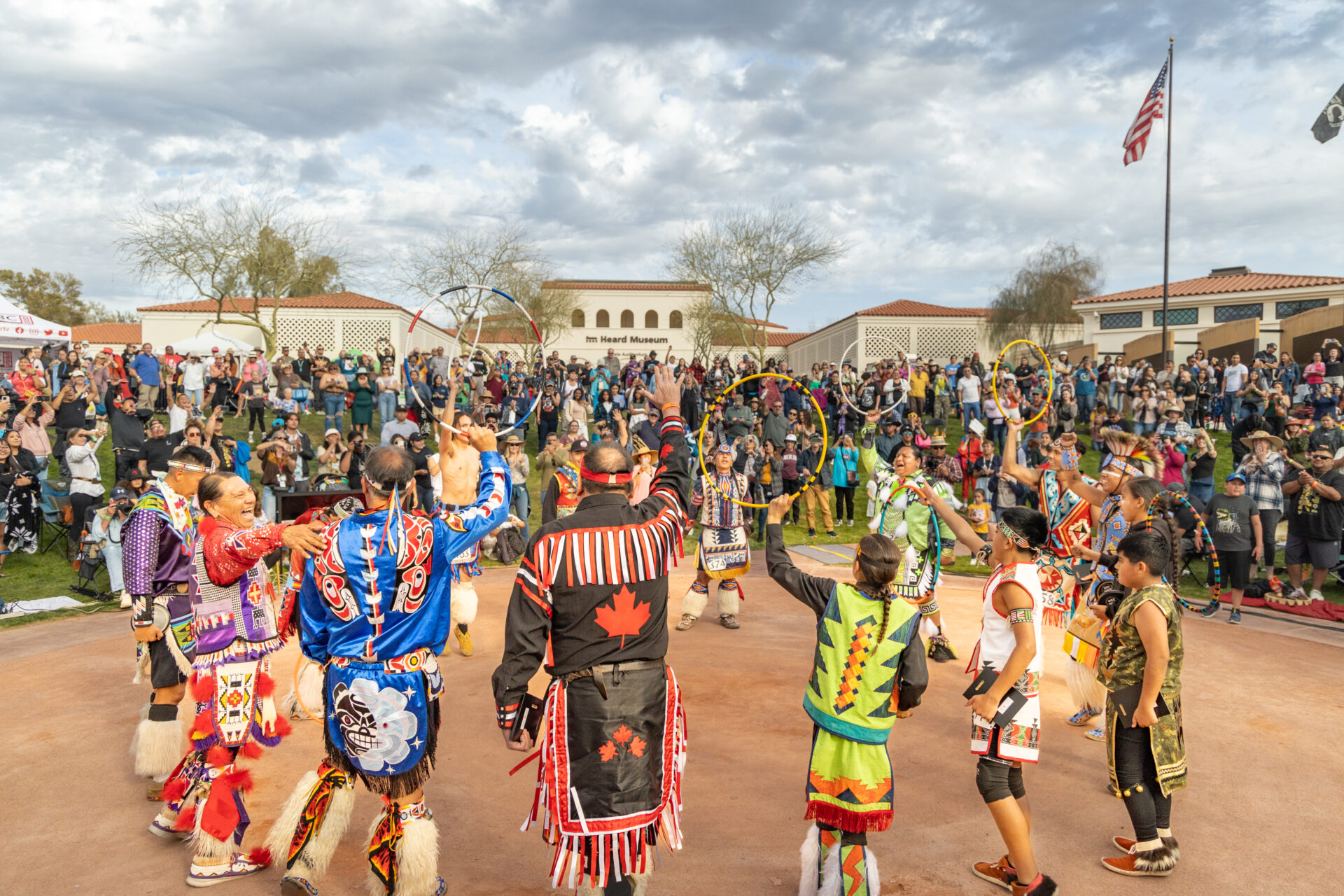 A group of native americans are dancing in front of a crowd.