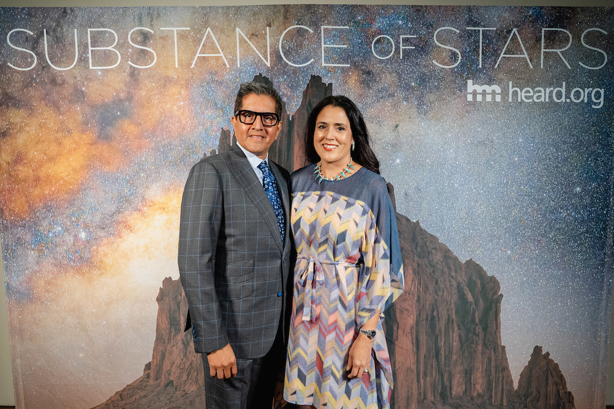 Two individuals posing for a moondance photo in front of a backdrop with the text "substance of stars heard.org".